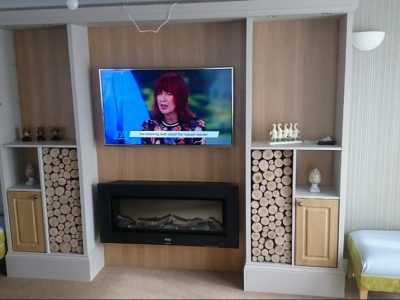 tv installed into modern brown alcove
